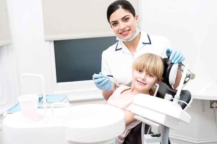 Girl child and dental hygienist at dental clinic