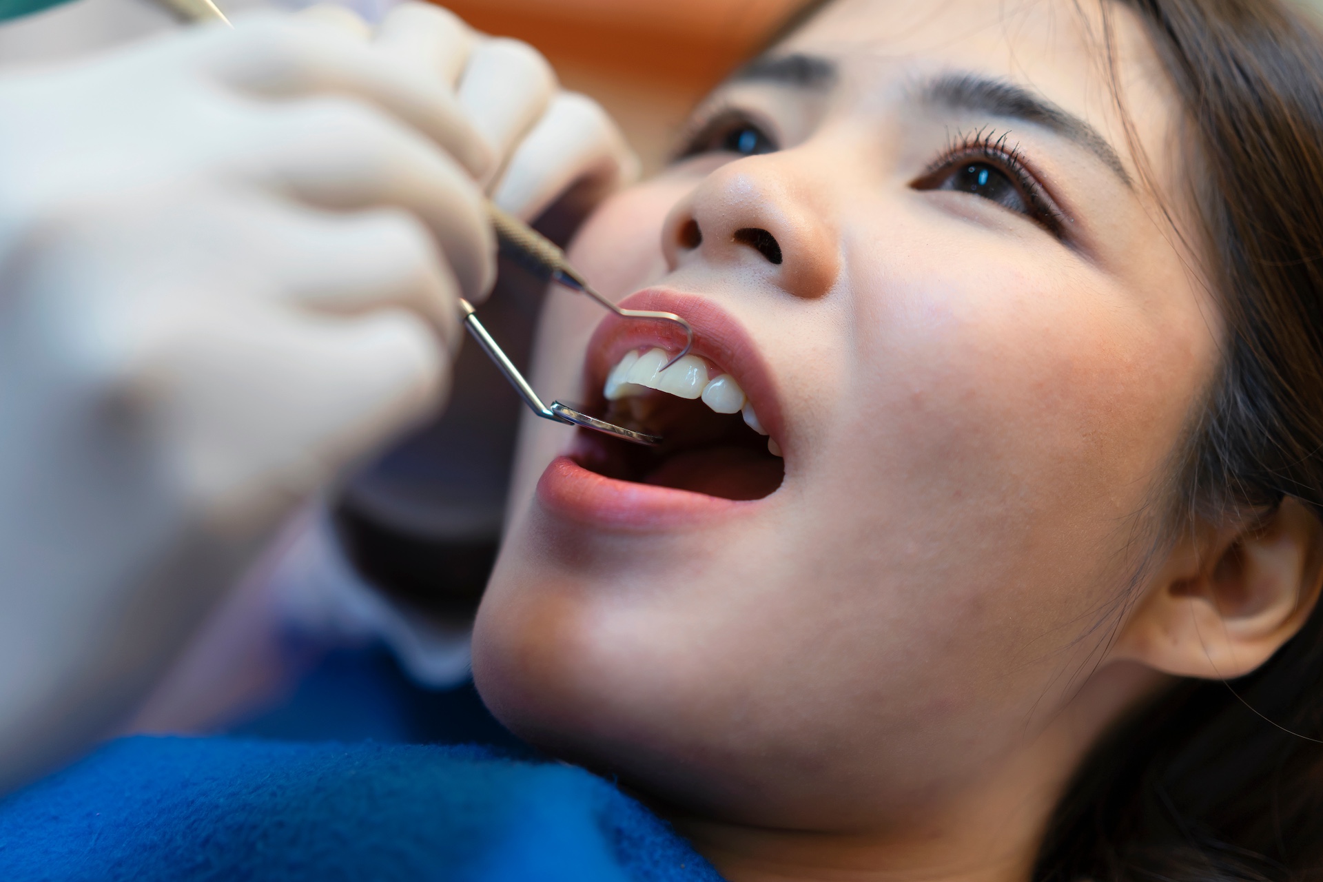 Dentist holding a dental tool of patients in the clinic.Woman lying on the dental chair for dentist checkup. Dentist holding a dental tool of patients in the clinic.Woman lying on the dental chair for dentist checkup.